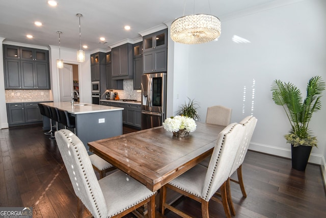 dining area featuring ornamental molding, dark hardwood / wood-style floors, and sink