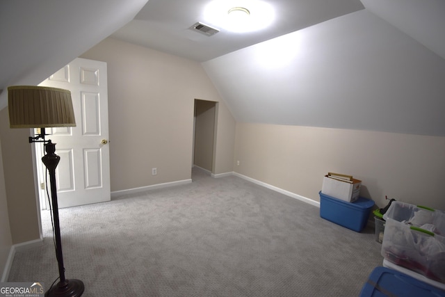 additional living space featuring vaulted ceiling and light carpet