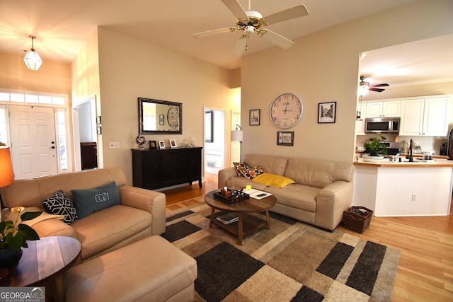 living room featuring ceiling fan and light hardwood / wood-style flooring