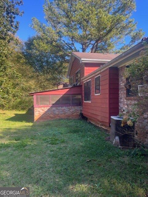 view of yard featuring central AC and a sunroom