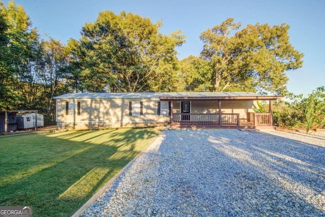 ranch-style house with a deck, a shed, and a front lawn