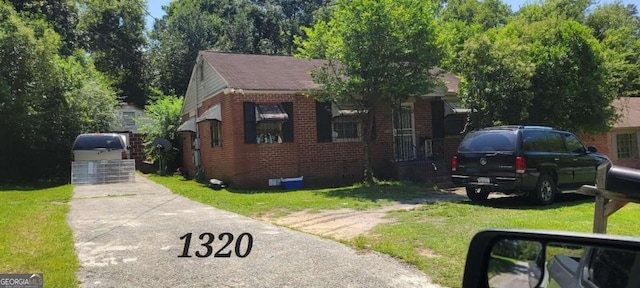 1320 Peavy Dr, Macon, GA 31206 - view of front facade featuring brick siding, a front yard, and a shingled roof