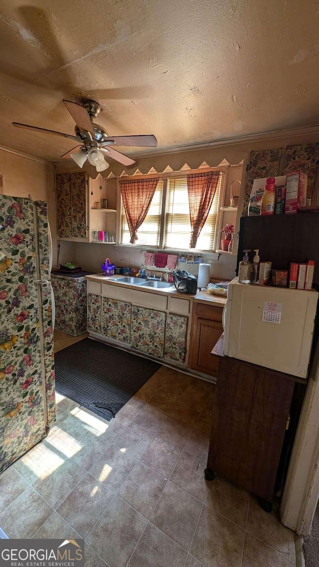 1870 Bethlea Ave, Macon, GA 31204 - kitchen with freestanding refrigerator, a sink, open shelves, a textured ceiling, and a ceiling fan