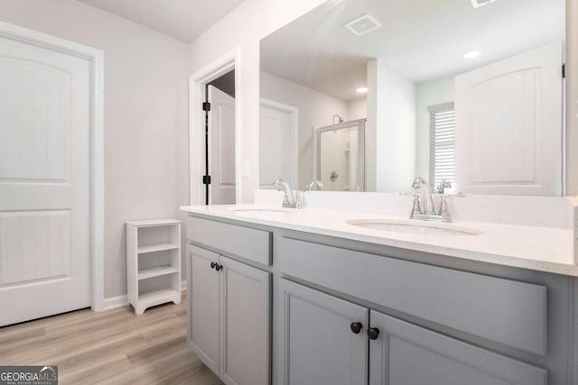 bathroom with vanity, hardwood / wood-style floors, and walk in shower