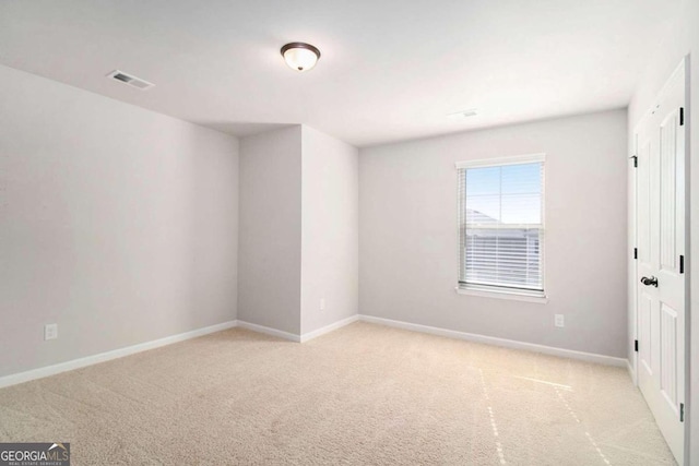 unfurnished room featuring light carpet