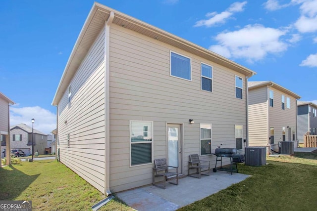 rear view of property with a yard, cooling unit, and a patio area