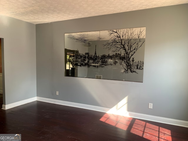 spare room with a textured ceiling and hardwood / wood-style flooring