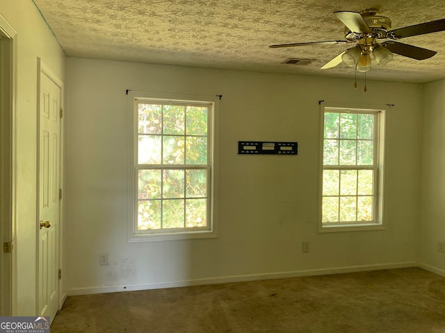 unfurnished room featuring ceiling fan, carpet flooring, and a textured ceiling