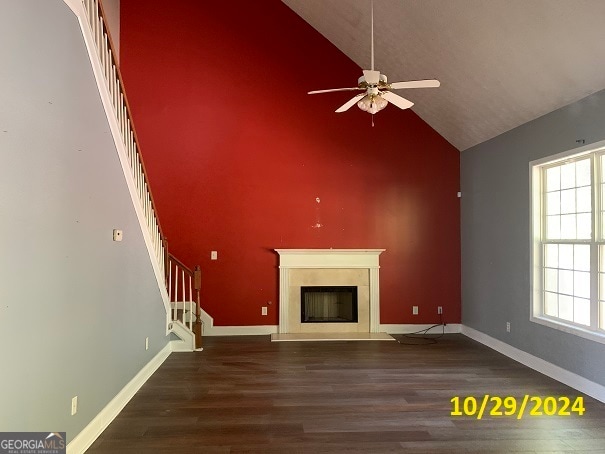 unfurnished living room with ceiling fan, high vaulted ceiling, and dark hardwood / wood-style flooring