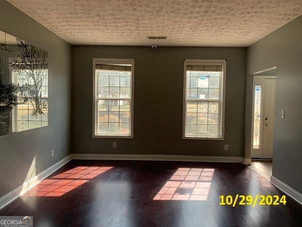 unfurnished room featuring dark hardwood / wood-style flooring and plenty of natural light