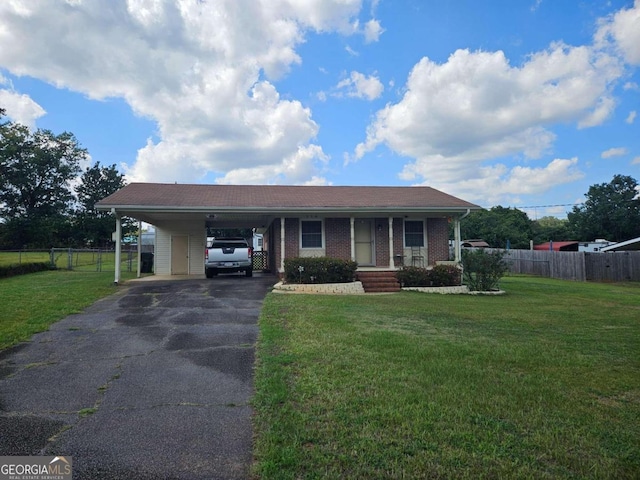 ranch-style house featuring a front lawn, a carport, and covered porch