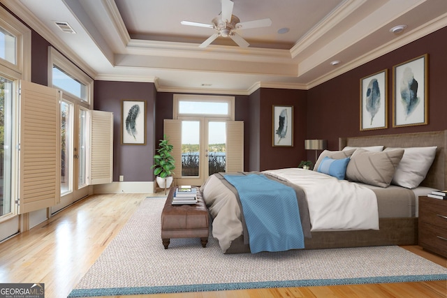 bedroom featuring a tray ceiling, wood finished floors, and ornamental molding