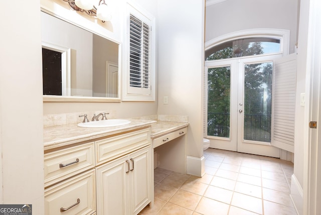 bathroom with tile patterned floors, toilet, vanity, and french doors