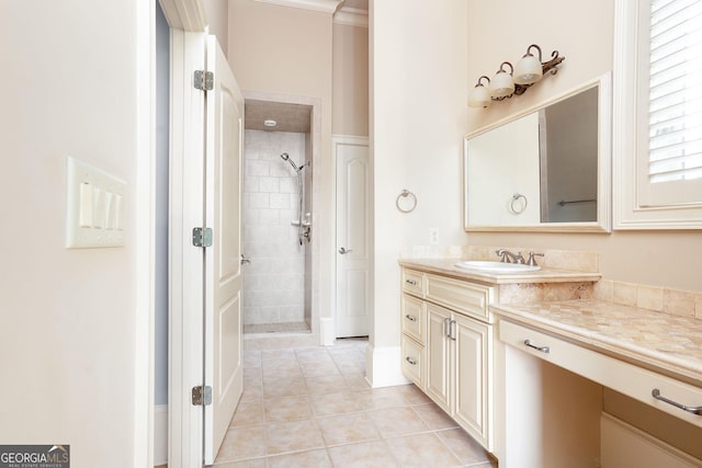 full bathroom with a tile shower, vanity, and tile patterned floors