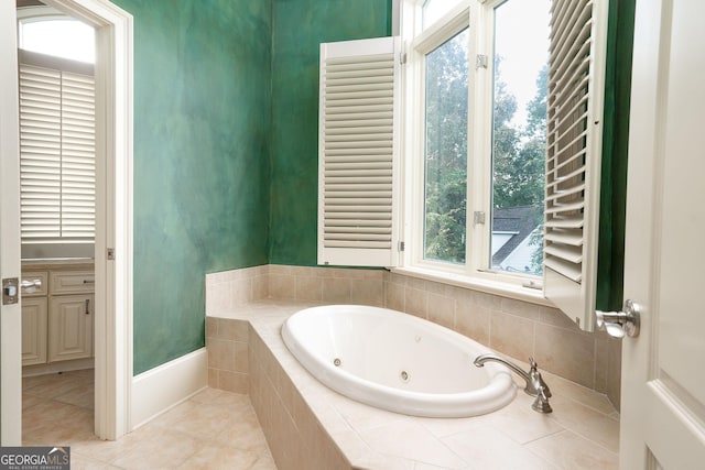 bathroom with a tub with jets and tile patterned floors