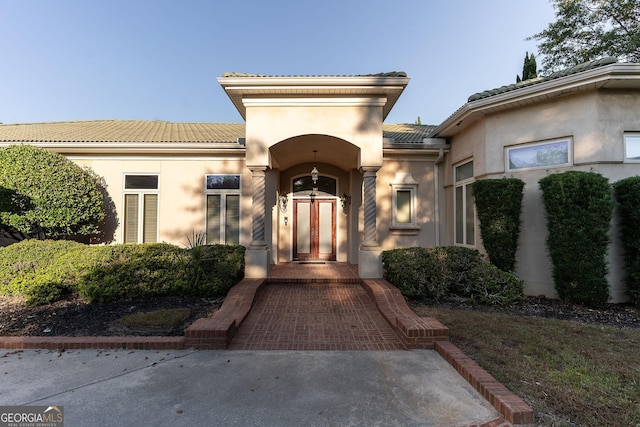 entrance to property with stucco siding and a tile roof