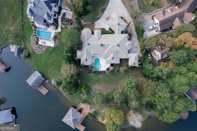aerial view of property and surrounding area featuring a pool and a nearby body of water