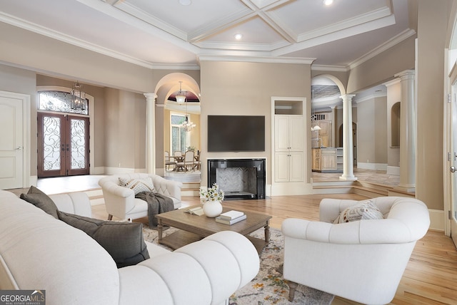 living room featuring ornate columns, plenty of natural light, french doors, a chandelier, and crown molding