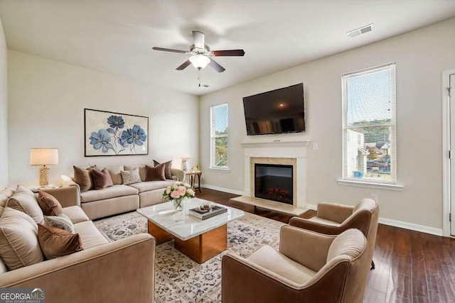 living room featuring dark wood-type flooring and ceiling fan