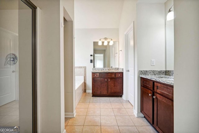 bathroom featuring vanity, a tub, and tile patterned floors