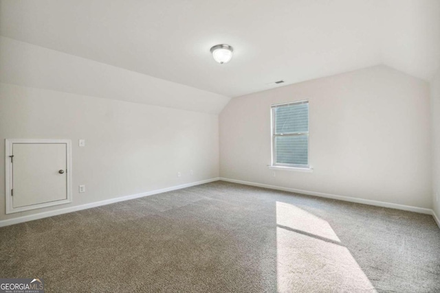 bonus room with carpet flooring and vaulted ceiling