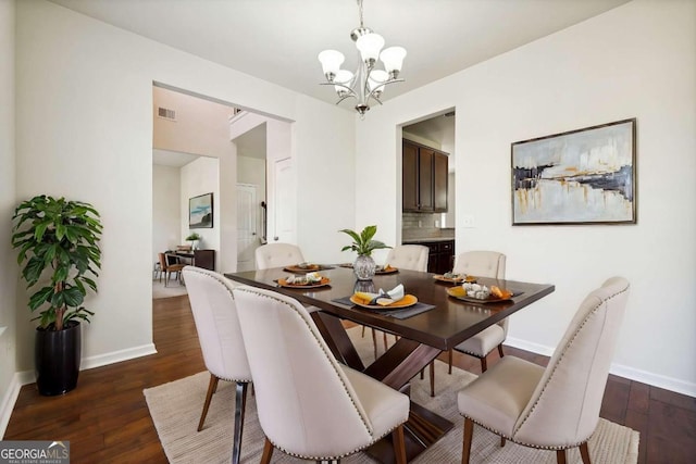 dining space featuring an inviting chandelier and dark hardwood / wood-style flooring