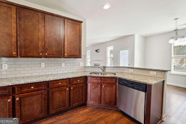 kitchen with light stone countertops, sink, stainless steel dishwasher, dark wood-type flooring, and decorative backsplash