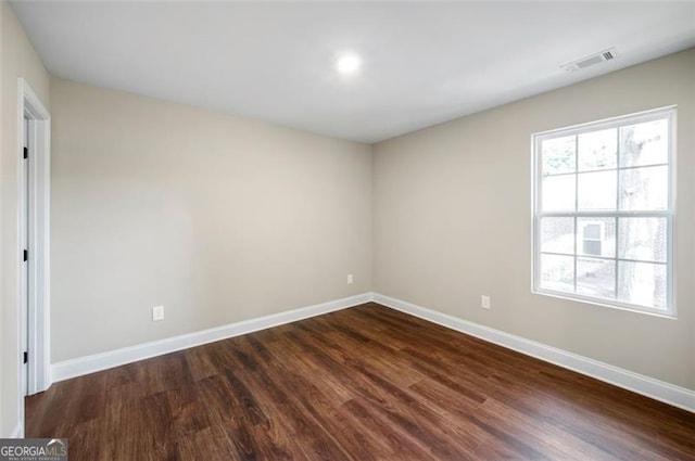 unfurnished room with dark wood-type flooring