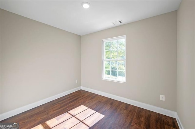 empty room with dark hardwood / wood-style flooring