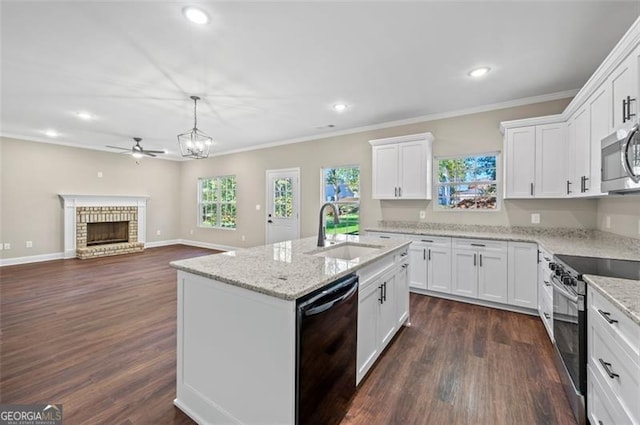 kitchen featuring sink, a center island with sink, pendant lighting, stainless steel appliances, and white cabinets