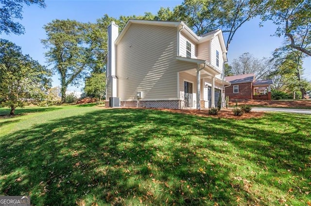 view of home's exterior featuring a garage, a yard, and central AC unit