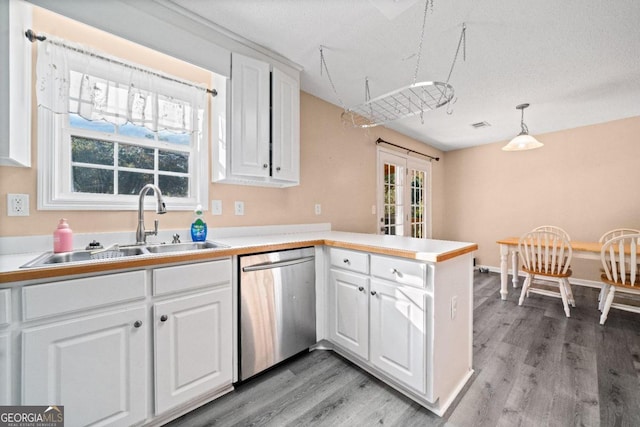 kitchen with a wealth of natural light, dishwasher, white cabinets, and kitchen peninsula