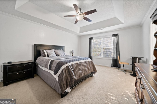 carpeted bedroom featuring ornamental molding, ceiling fan, a textured ceiling, and a raised ceiling