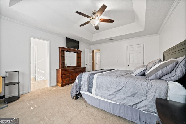 bedroom featuring ceiling fan, a raised ceiling, carpet, and crown molding