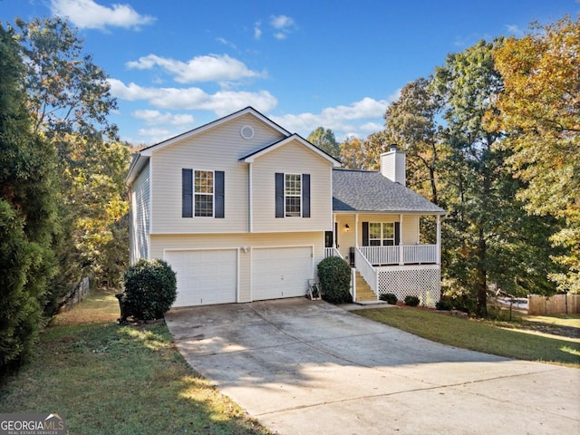 tri-level home featuring covered porch, a front lawn, and a garage