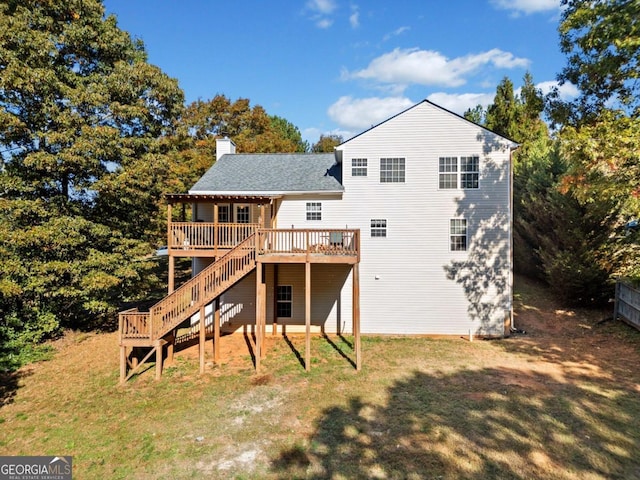 rear view of house featuring a wooden deck and a lawn