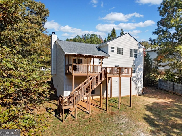 rear view of property featuring a deck and a lawn