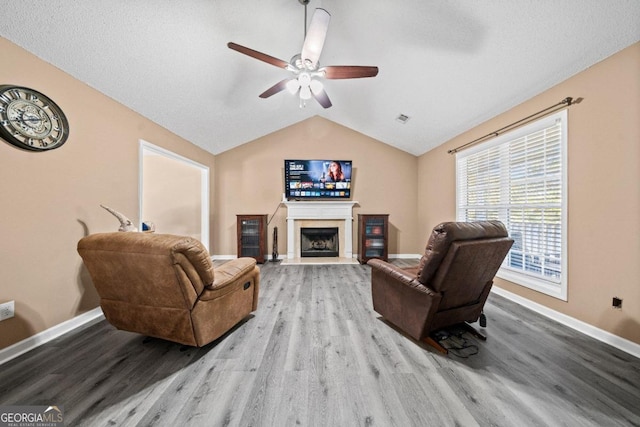 living room featuring vaulted ceiling, light hardwood / wood-style flooring, and ceiling fan