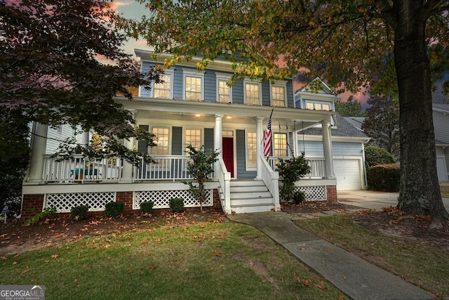 colonial-style house with a lawn, a porch, and a garage