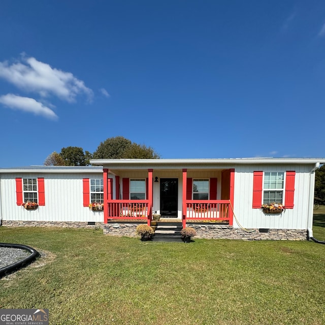 manufactured / mobile home featuring covered porch and a front yard