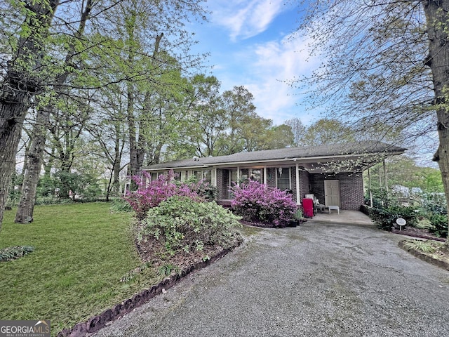 single story home with a front yard and a carport