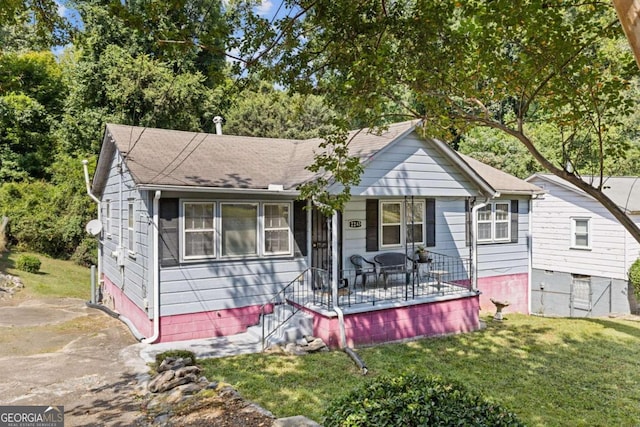 bungalow-style home with a front yard and a wooden deck