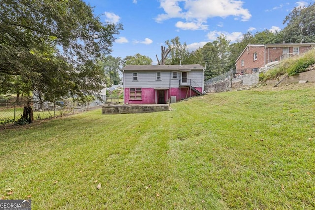 rear view of house featuring a lawn