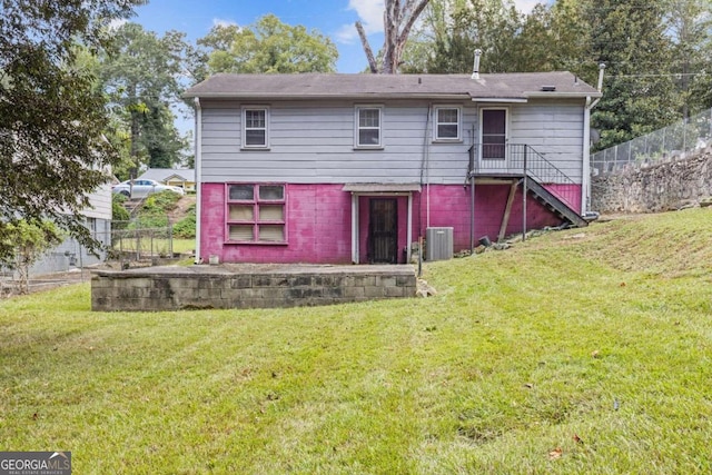 back of house featuring a yard and central air condition unit