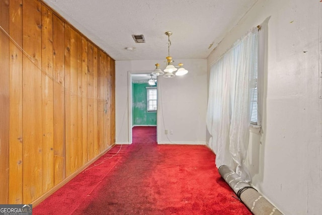 carpeted dining area with wood walls