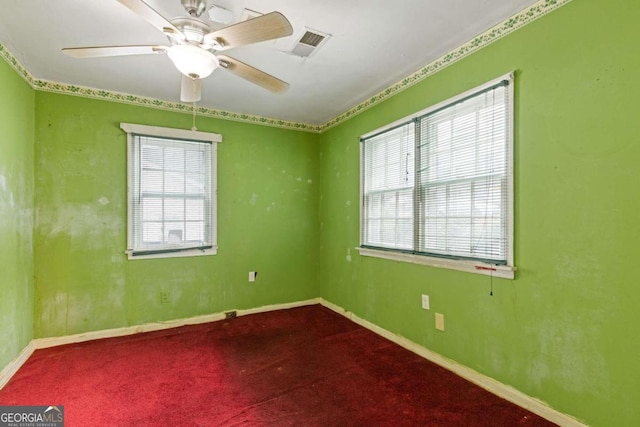 carpeted spare room featuring ceiling fan and a wealth of natural light