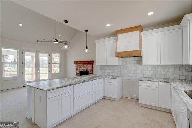 kitchen featuring white cabinets, decorative backsplash, kitchen peninsula, and ceiling fan