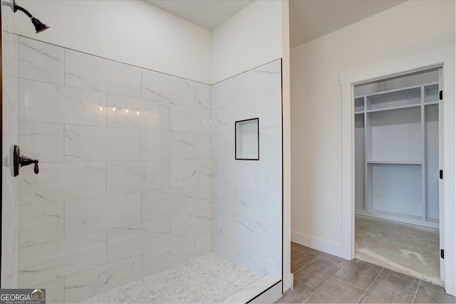 bathroom featuring tile patterned flooring and a tile shower