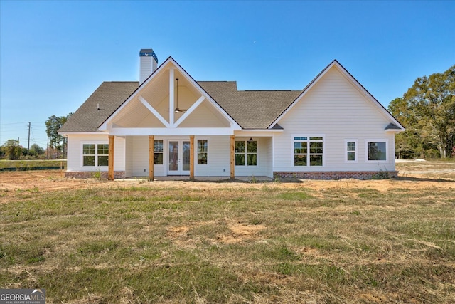 back of property with a yard and french doors