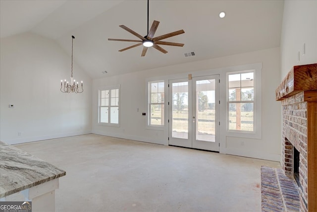 unfurnished living room with ceiling fan with notable chandelier, high vaulted ceiling, and a brick fireplace